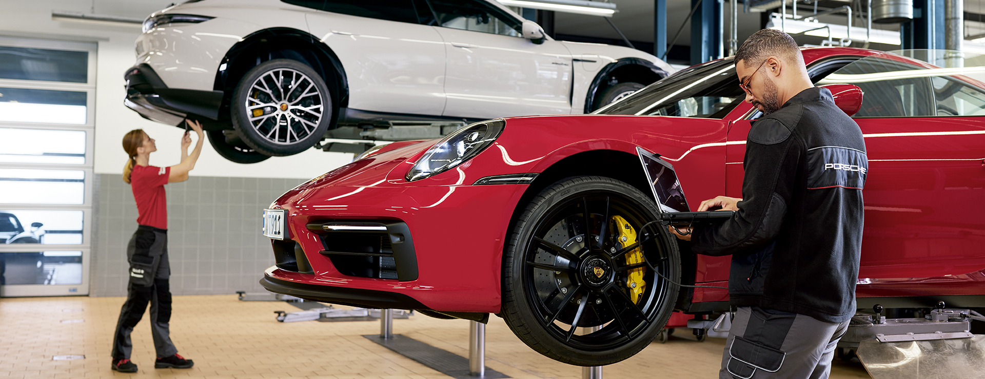 Zwei Porsche Mitarbeiter arbeiten in der Porsche Werkstatt.